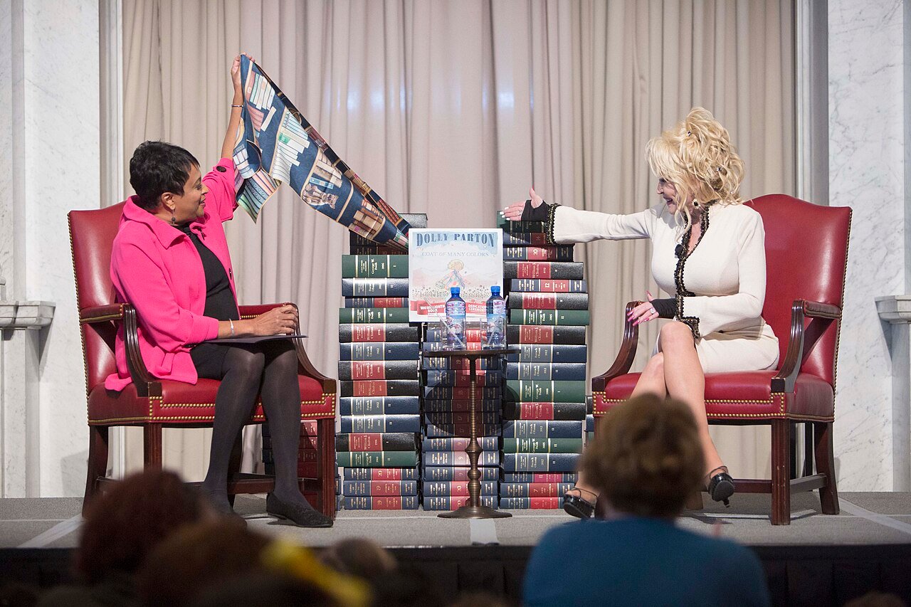 Librarian of Congress Carla Hayden (left) and Dolly Parton unveil “Coat of Many Colors,” the book Parton donated to the Library this week.jpg